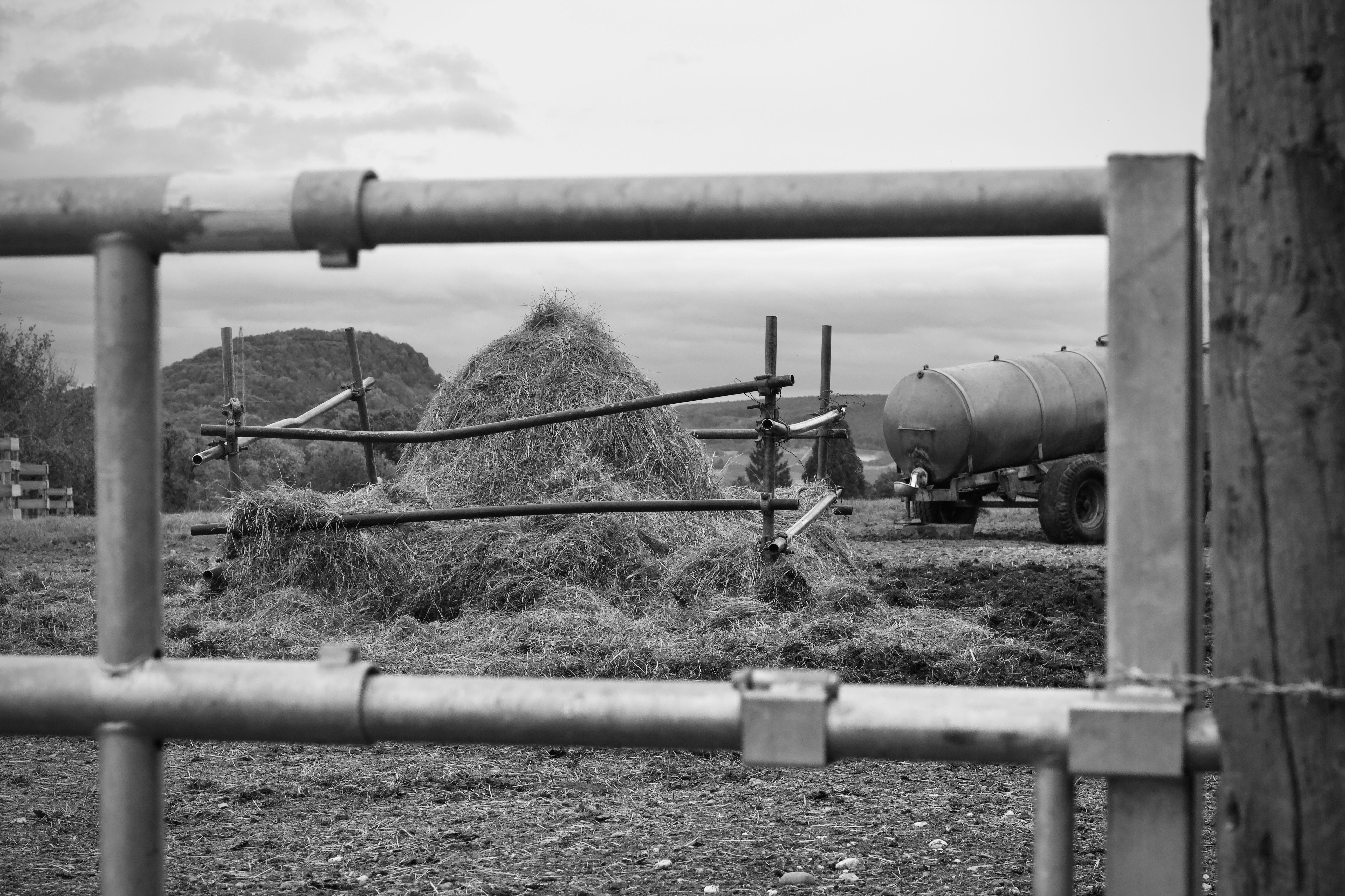 Rural Farm Scene with Haystack and Water Tanker · Free Stock Photo