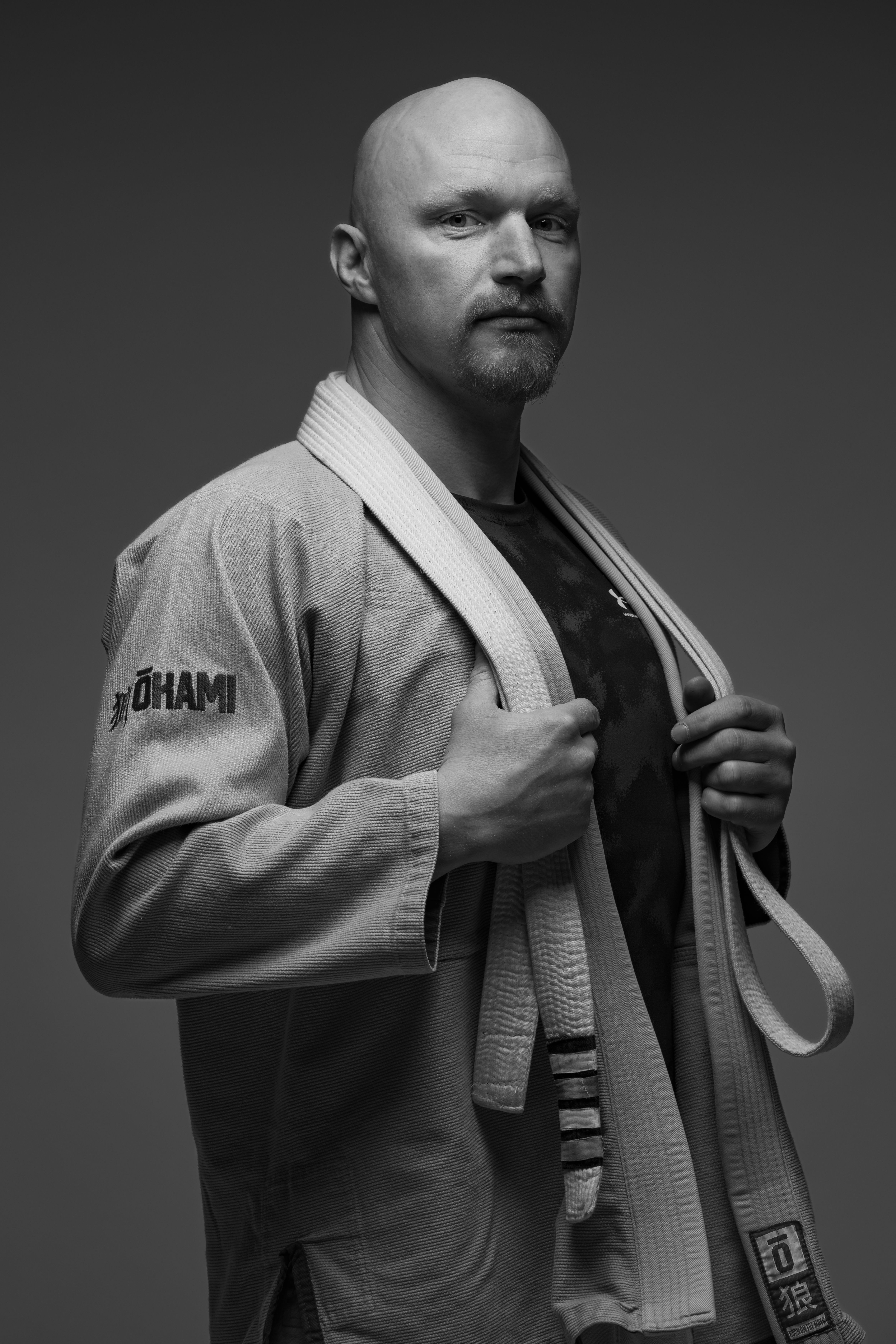 Black and white portrait of a martial artist in a Gi with confident pose.