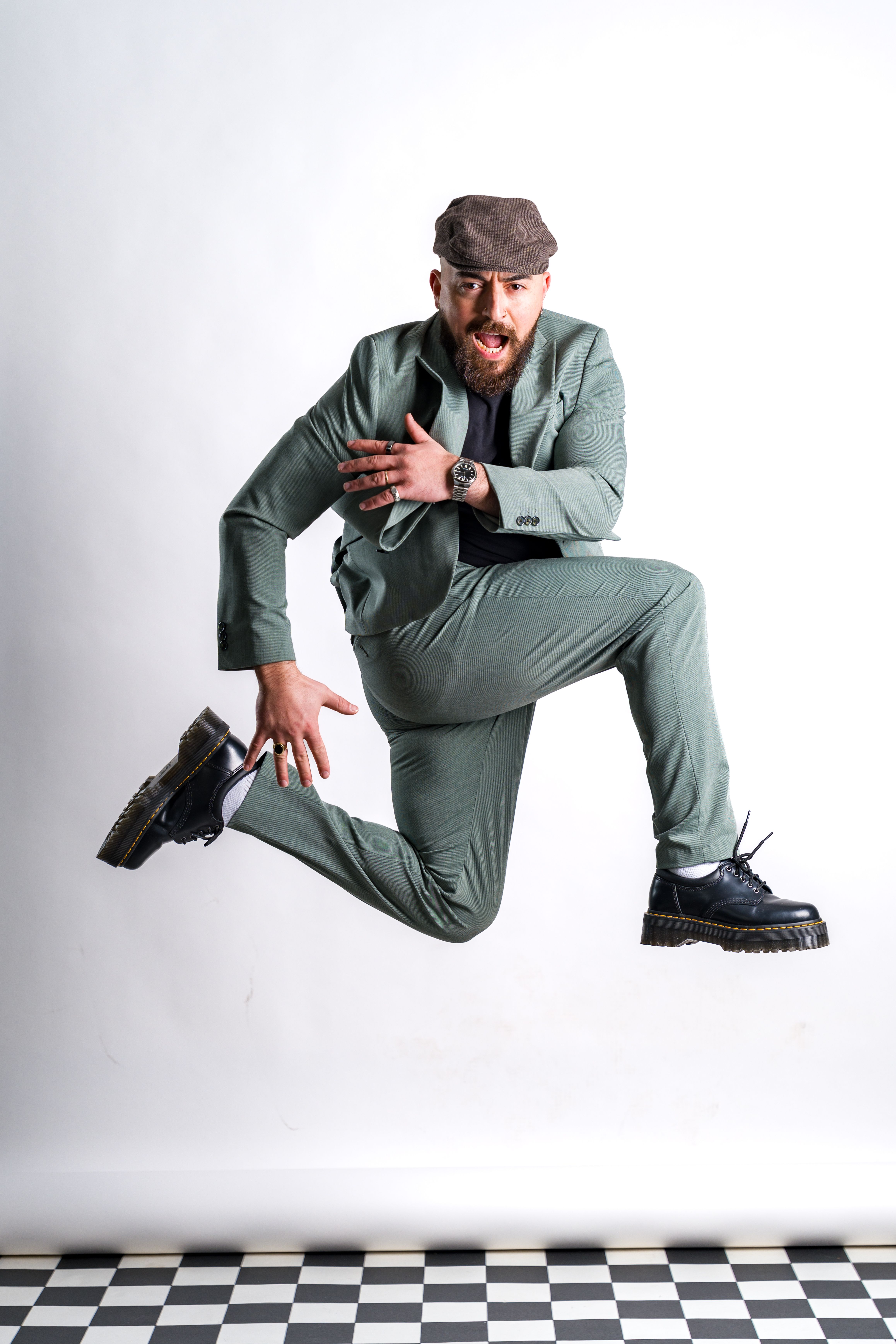 Fashionable man in mid-air jump, showcasing style and energy.