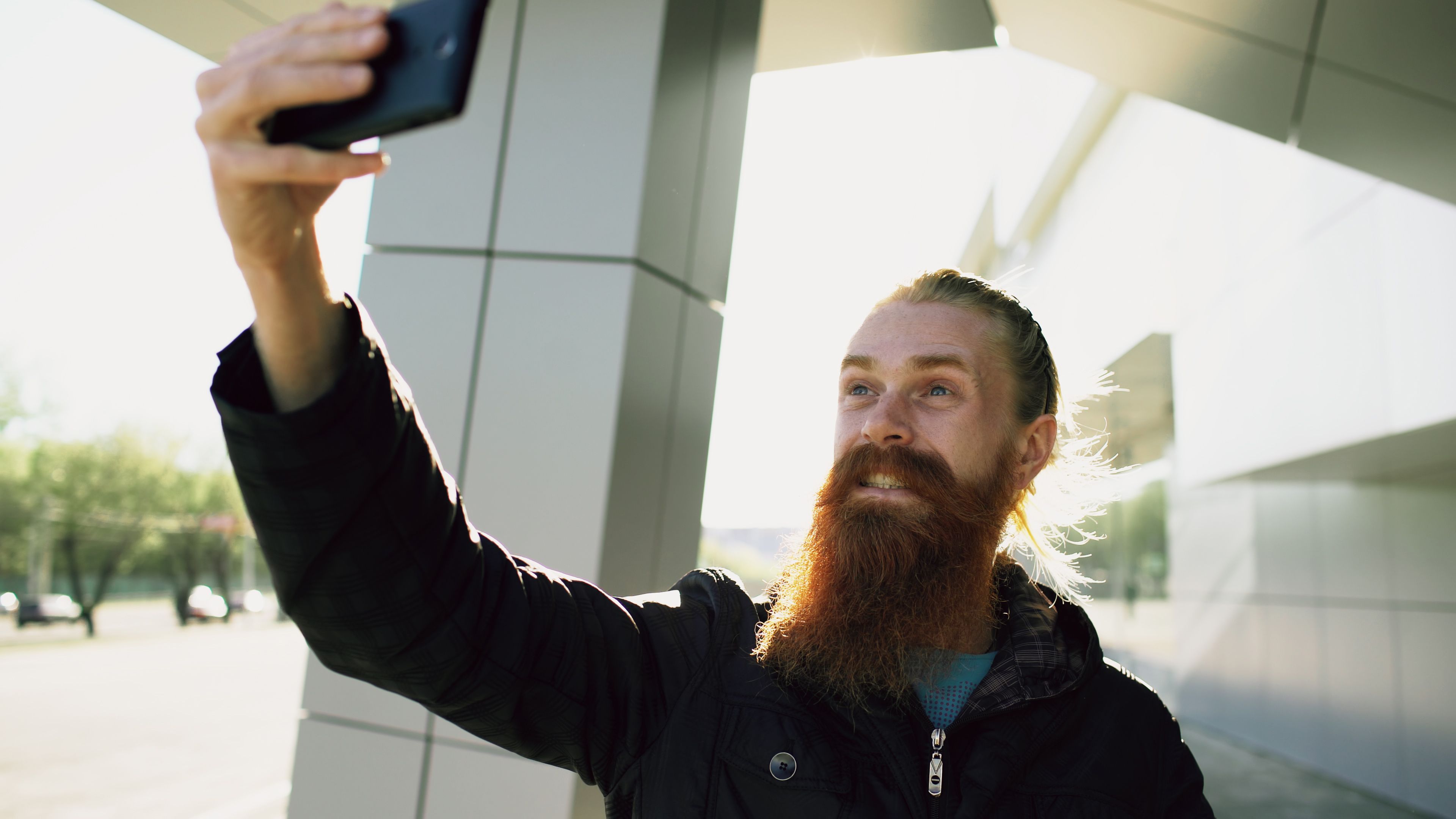 Man reviewing a selfie on his phone before posting it to a rating subreddit