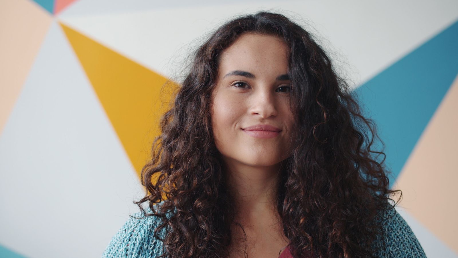 Smiling woman with long dark curly hair