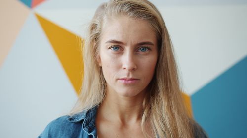 Free Close-up of a woman with blonde hair against a colorful geometric background. Stock Photo