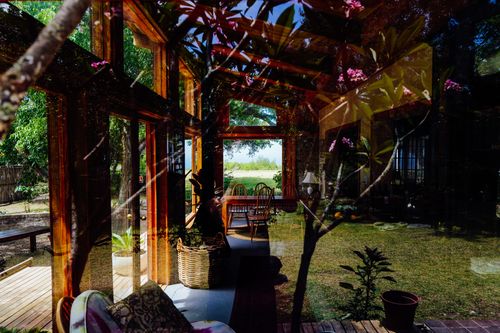 Free Sunlit interior with wooden furniture and garden view, creating a serene atmosphere. Stock Photo