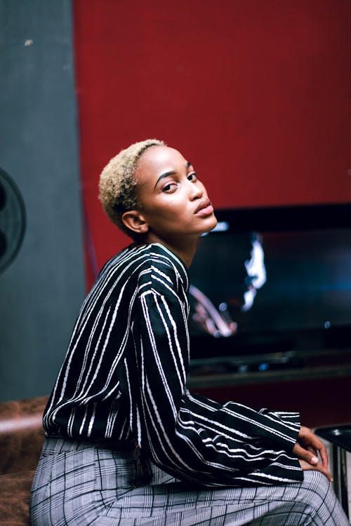 Woman in Black and White Striped Long Sleeve Shirt Sitting on Chair