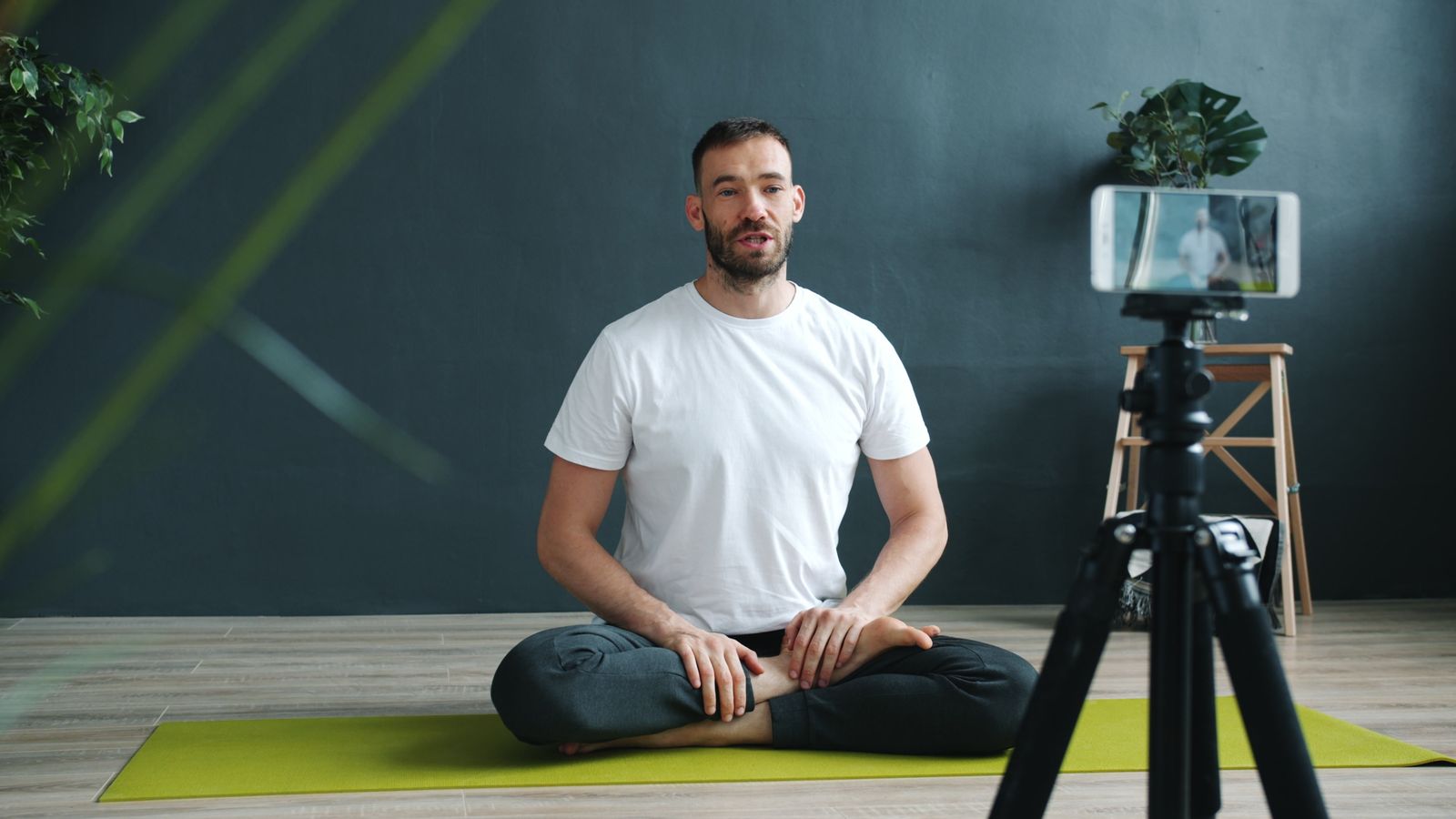 Yoga instructor filming an online class session, representing a digital yoga career opportunity