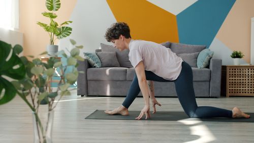 Free A person practicing yoga indoors with a stylish geometric wall design. Stock Photo