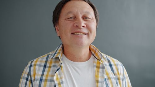 Free Close-up portrait of a smiling man wearing a plaid shirt, exuding warmth and positivity. Stock Photo