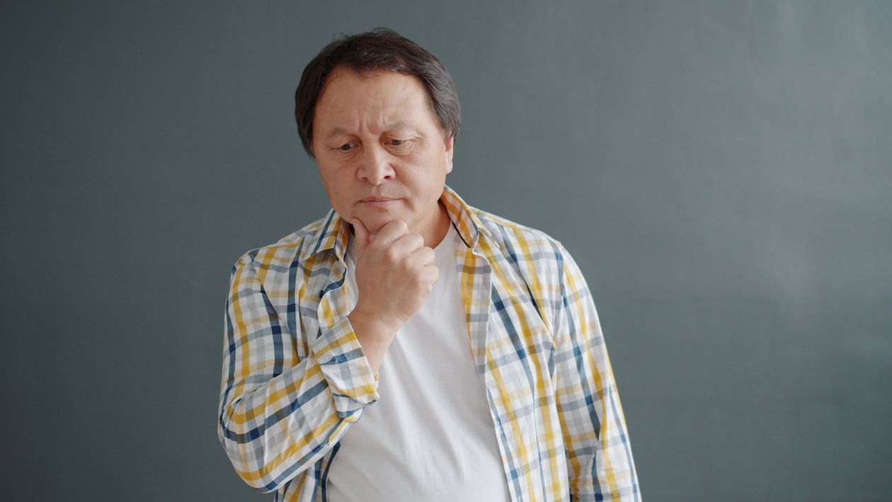 A man sitting indoors, deep in thought