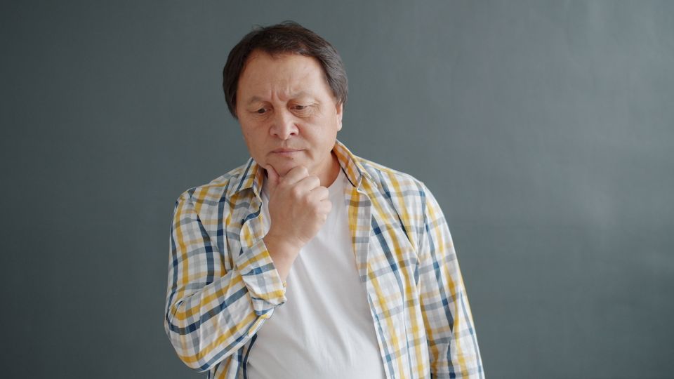 A man in a plaid shirt thinking something over