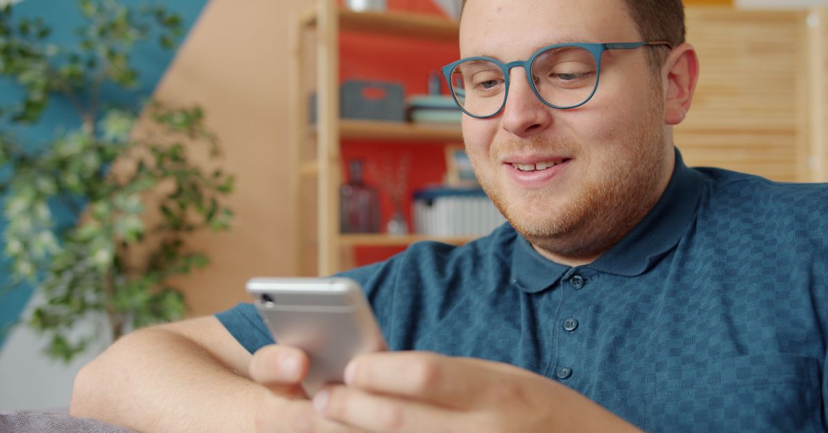 Person scrolling through a long list of contacts on a smartphone with a thoughtful expression