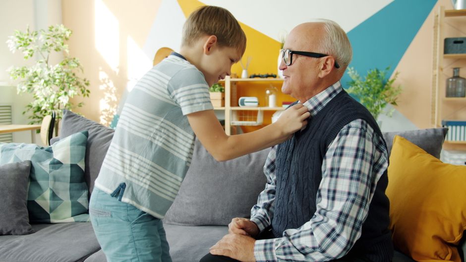 A senior man and a young boy enjoy a bonding moment at home, showcasing family love. A senior man and a young boy enjoy a bonding moment at home, showcasing family love.