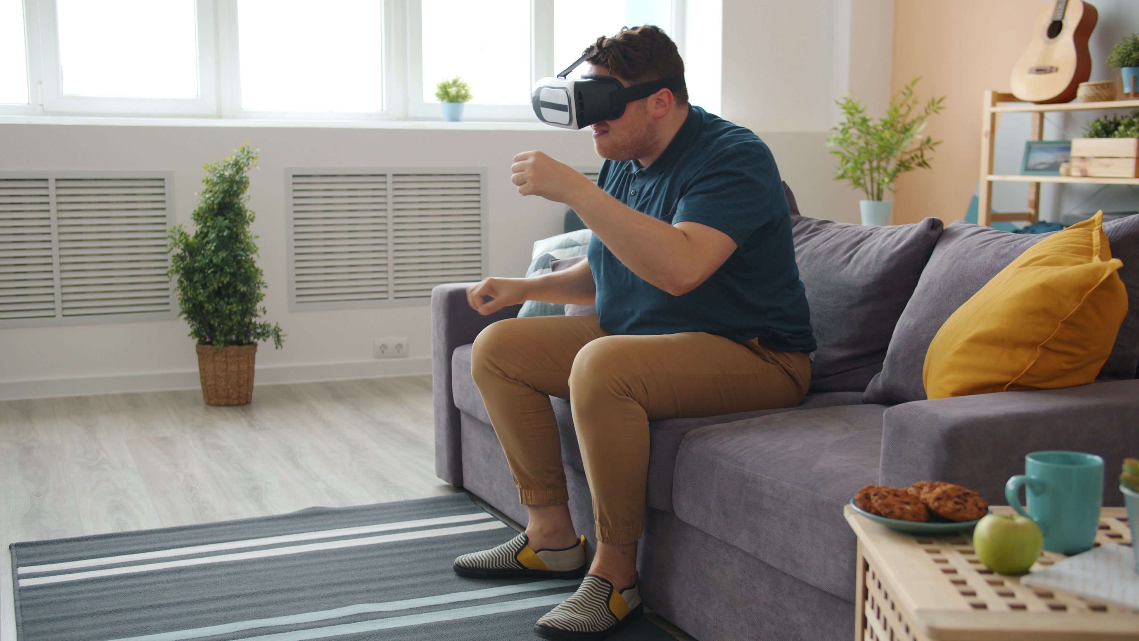 Adult male immersed in virtual reality gaming from a cozy living room.