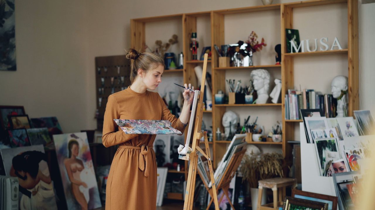 female artist working on canvas in her art studio