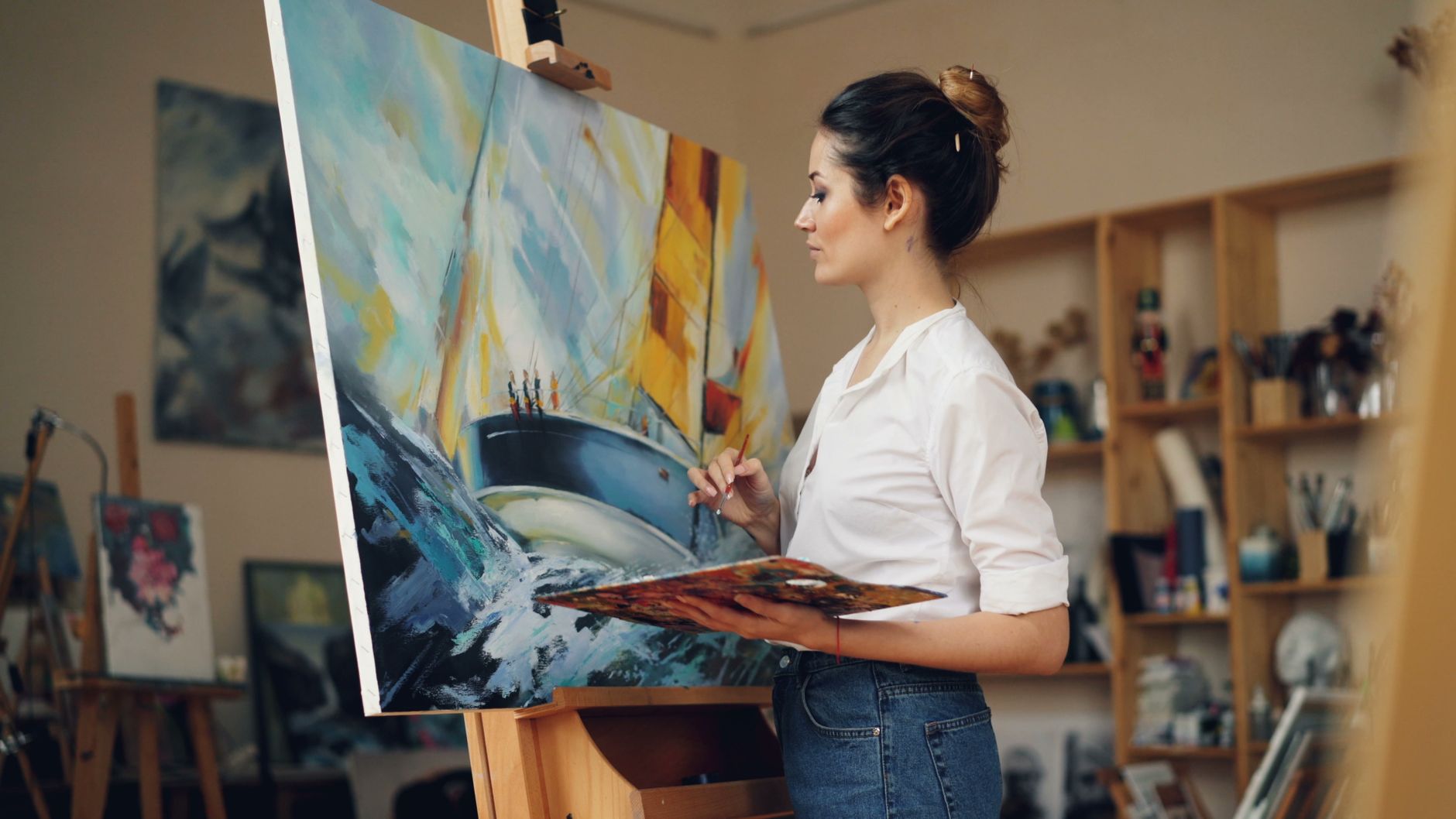 Female artist creating vibrant painting in her art studio.