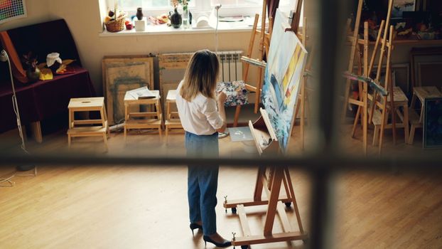 Jak poprawić koncentrację dzięki mikrodawkowaniu: sprawdzone techniki na 2026 3 Artist focused on painting in a well-lit studio filled with art supplies.