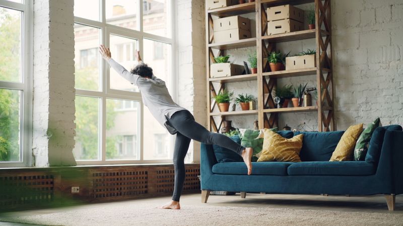 Person stretching in a bright room representing NEAT