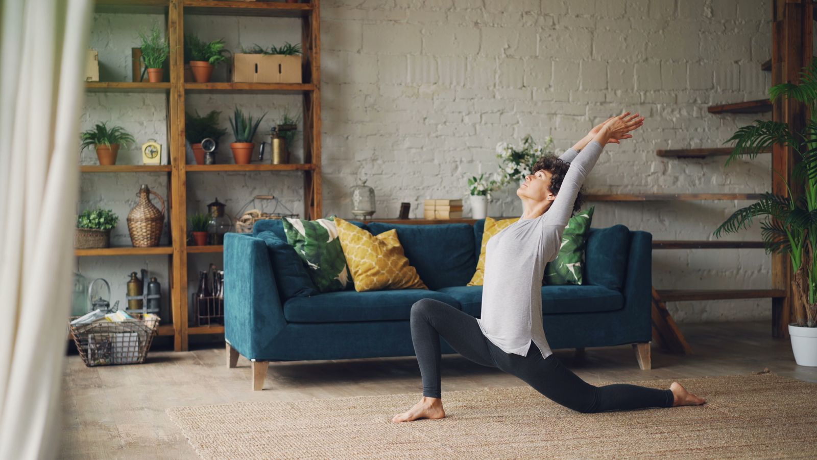 Person practicing a yoga pose at home during a self-guided session