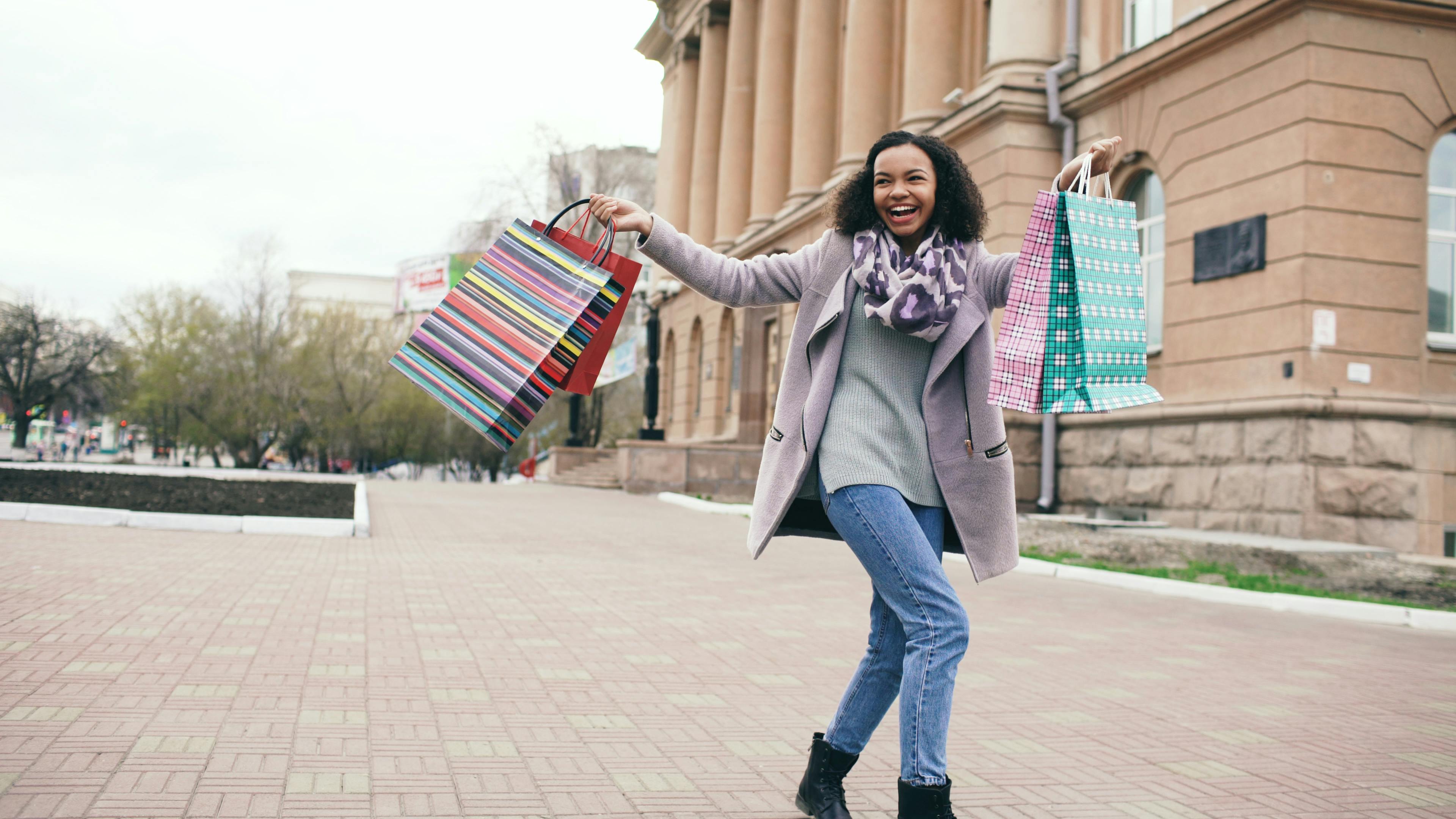 woman smiling with shopping bags showing ways to save money every month