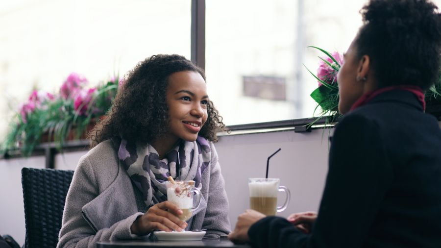 Two friends chatting over coffee at a cafe
