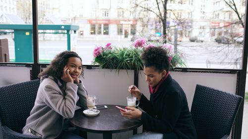 Free Two women enjoying coffee and conversation at an outdoor cafe. Stock Photo