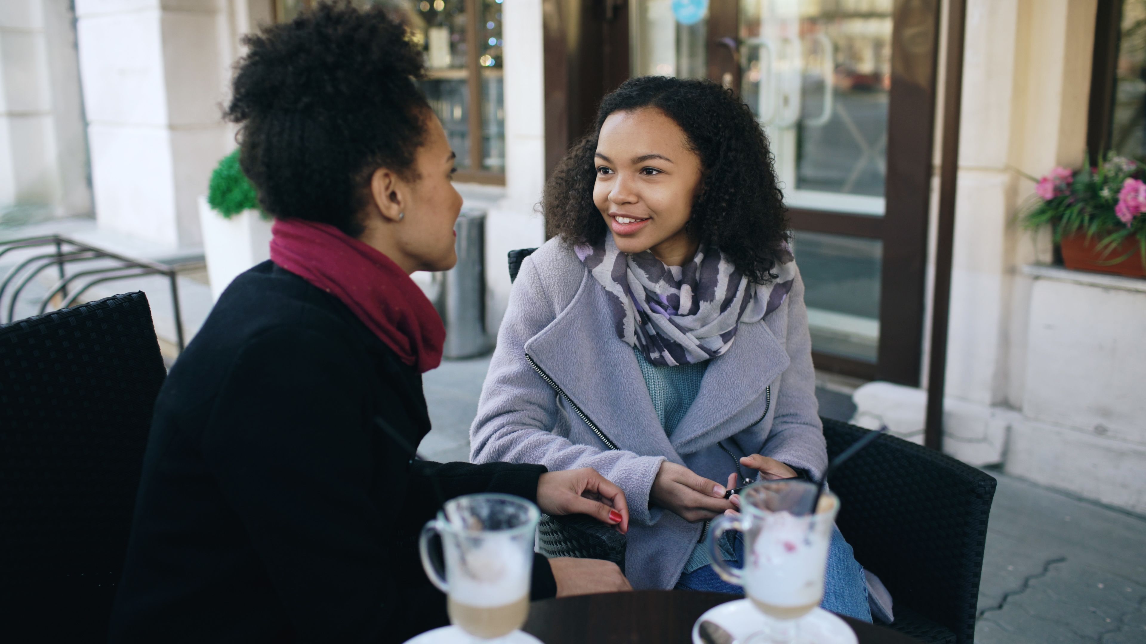 Two business owners having a warm conversation over coffee at an outdoor café