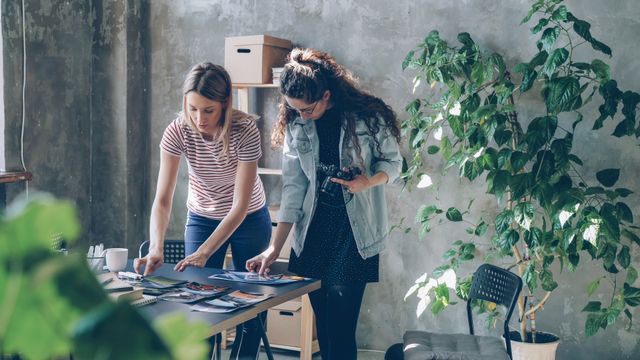 Two designers reviewing printed work — photo by Vitaly Gariev on Pexels