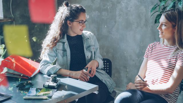 Two people sharing coffee and conversation at a small café table