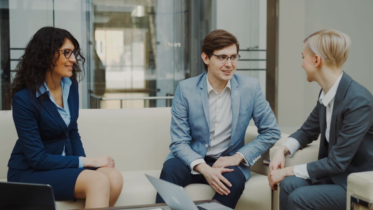 Profesionales con trajes y blazers conversando sobre estrategia