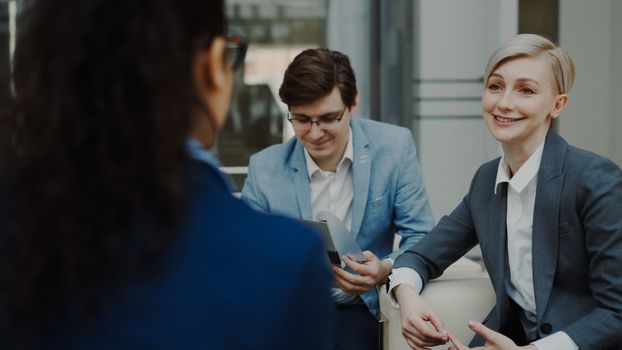 Three professionals engaged in a business meeting indoors.