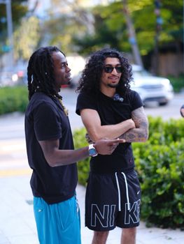 Two adults having a relaxed conversation outdoors in a vibrant city setting.