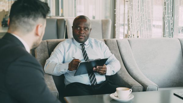 Two businessmen having a meeting in a modern cafe, engaged in discussion.