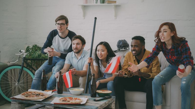 Amigos assistindo jogo de futebol juntos na televisão