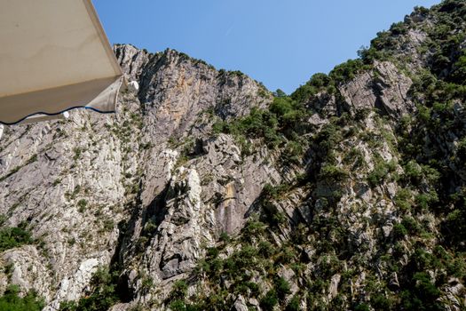 Discover the stunning rocky cliffs of Koman in Shkodër County, Albania, under a clear blue sky.