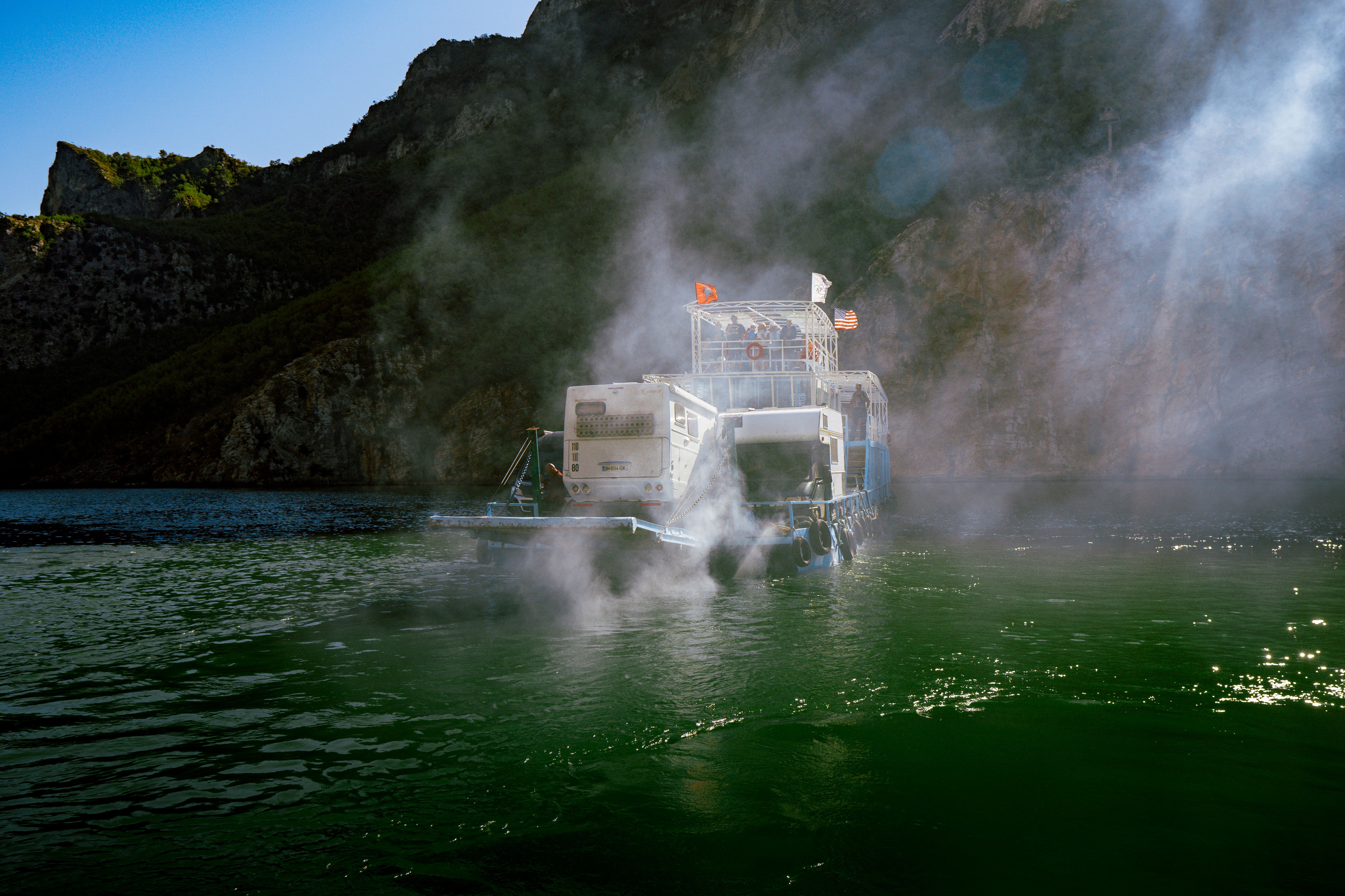 Scenic view of Komani Lake with a ferry navigating through mountains in Albania