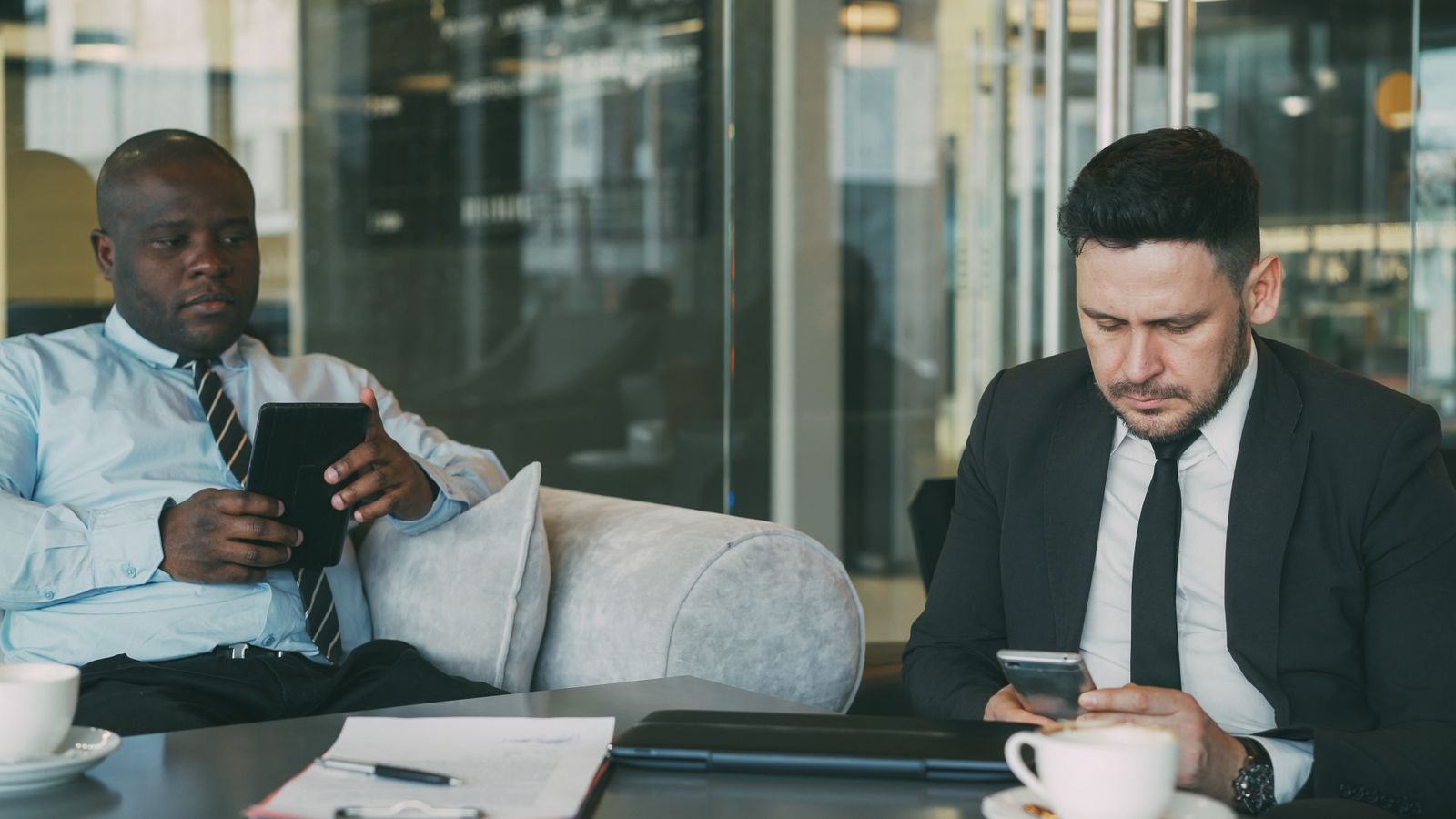 Fragmented Fleets: Restoring Executive Control Over Scattered Corporate and BYOD Hardware Ecosystems 10 unified endpoint management consulting services: executives using tablets and phones in an office lounge.