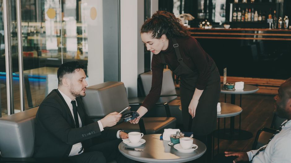 Business owner checking the Stripe transaction fee on a laptop at a counter