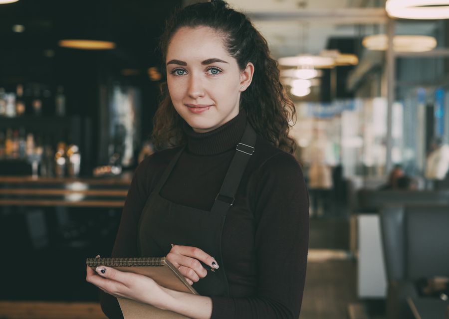 A server greeting guests in an upscale restaurant