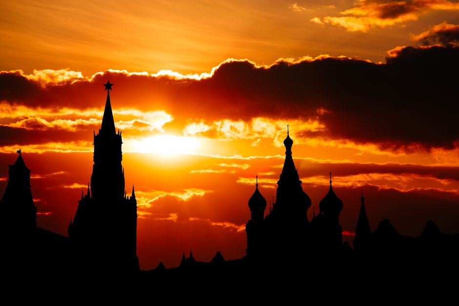 Dramatic silhouette of Moscow Kremlin towers against a vibrant sunset sky.