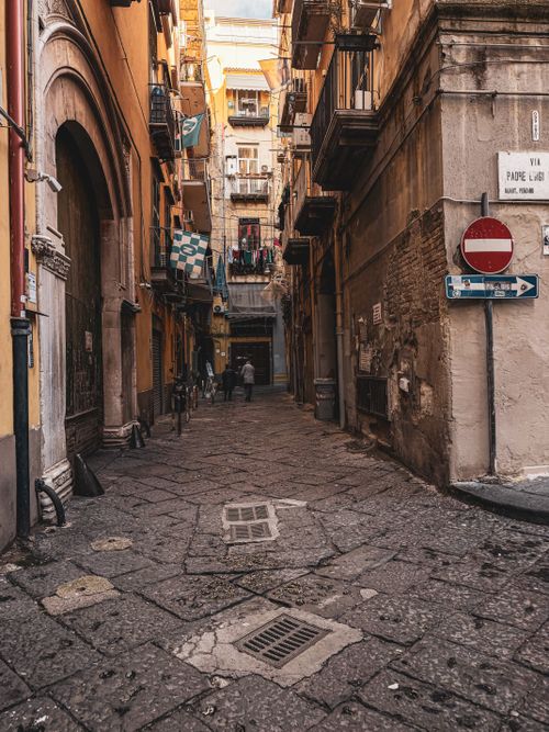 Free A picturesque narrow street in a historic European city, showcasing vibrant architecture and cultural charm. Stock Photo