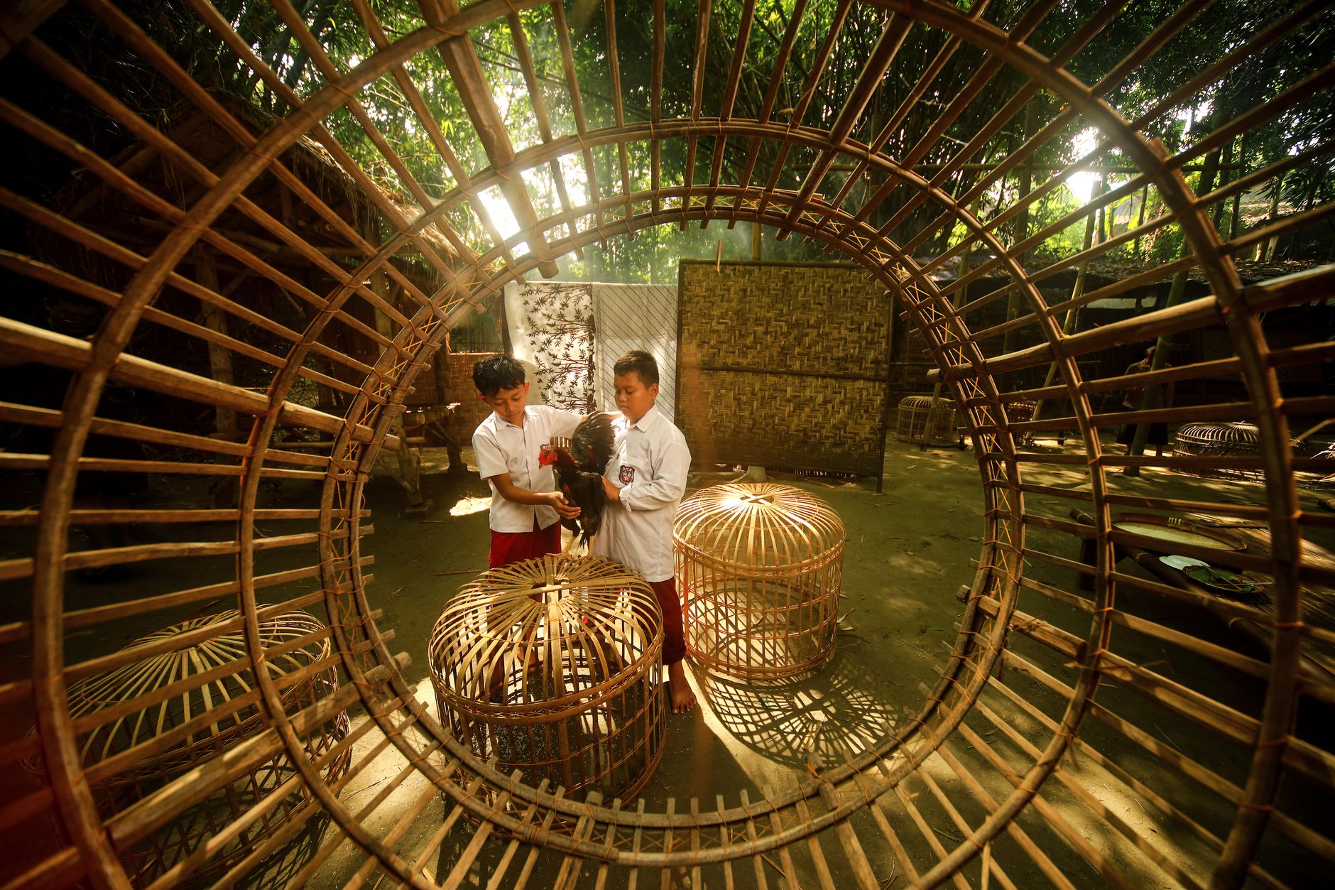 Two students learn traditional bird cage construction in Yogyakarta, Indonesia.