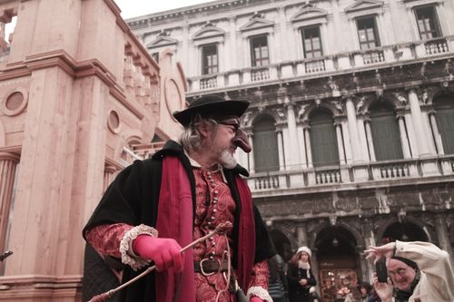 Free A vibrant carnival costume in St. Mark's Square, Venice with historical architecture. Stock Photo