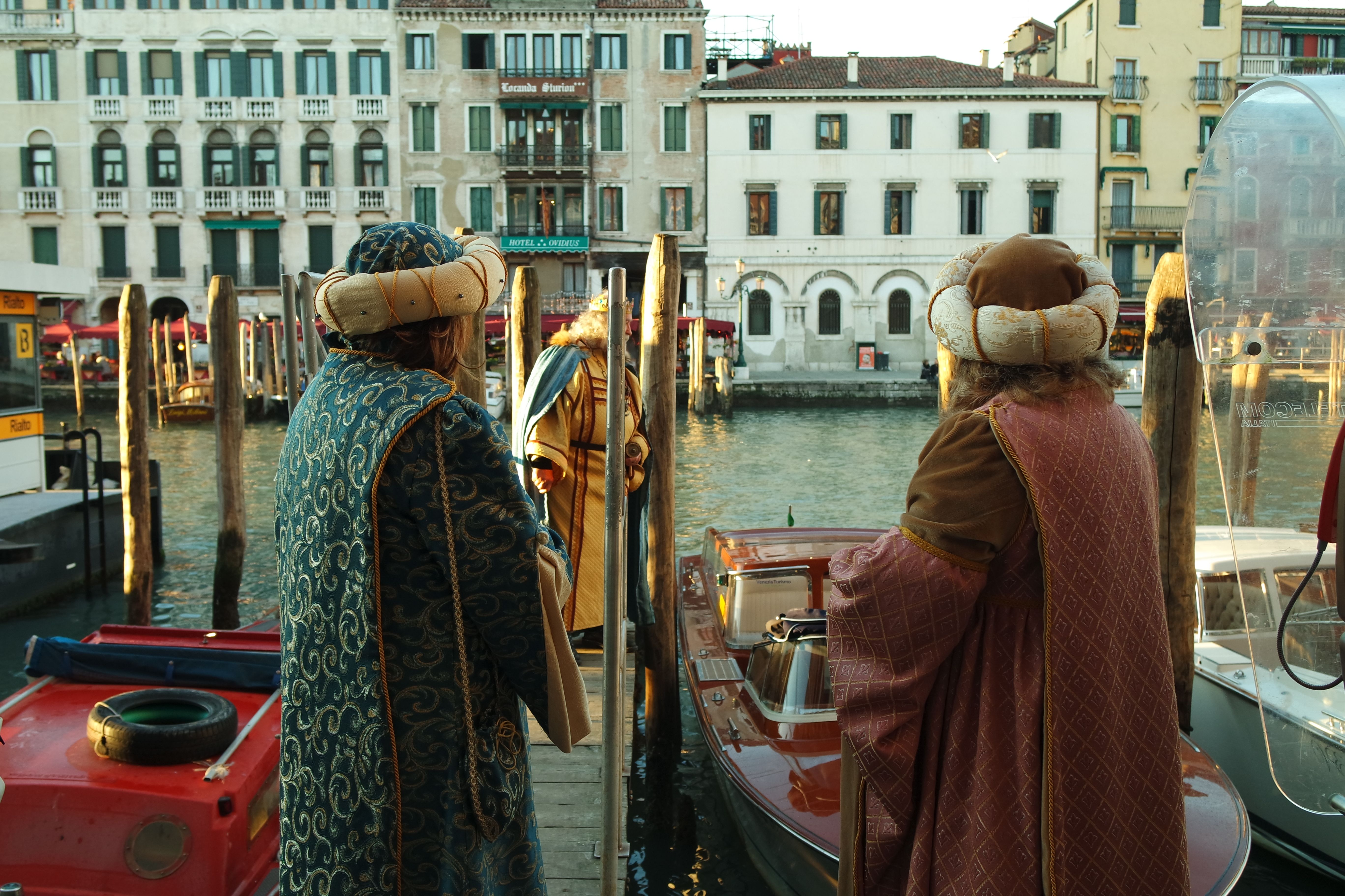 Gratis Uomini in abiti tradizionali si trovano vicino a un taxi acqueo a Venezia, in Italia. Foto a disposizione