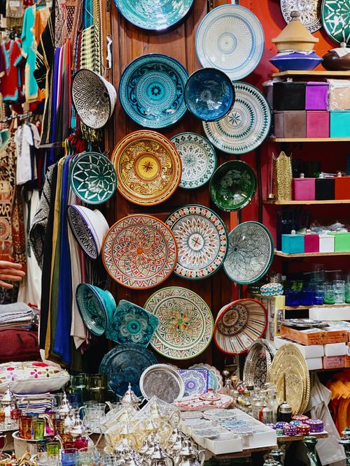 Free Colorful pottery and goods on display at Marrakech market in Morocco's medina. Stock Photo