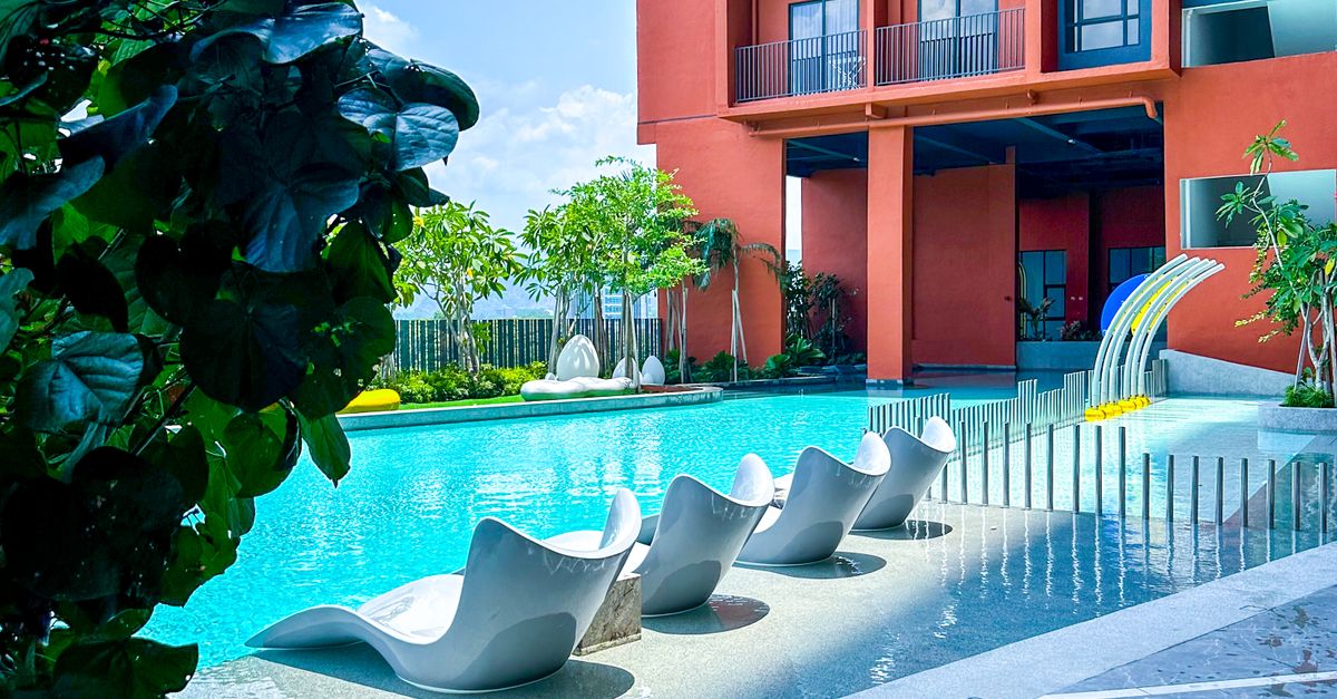 A vibrant poolside scene at a modern resort in Ipoh, Malaysia, showcasing luxurious amenities and architecture.