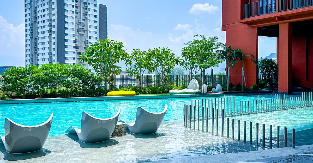 Luxurious poolside setting in a modern urban environment in Ipoh, Malaysia, under a bright blue sky.