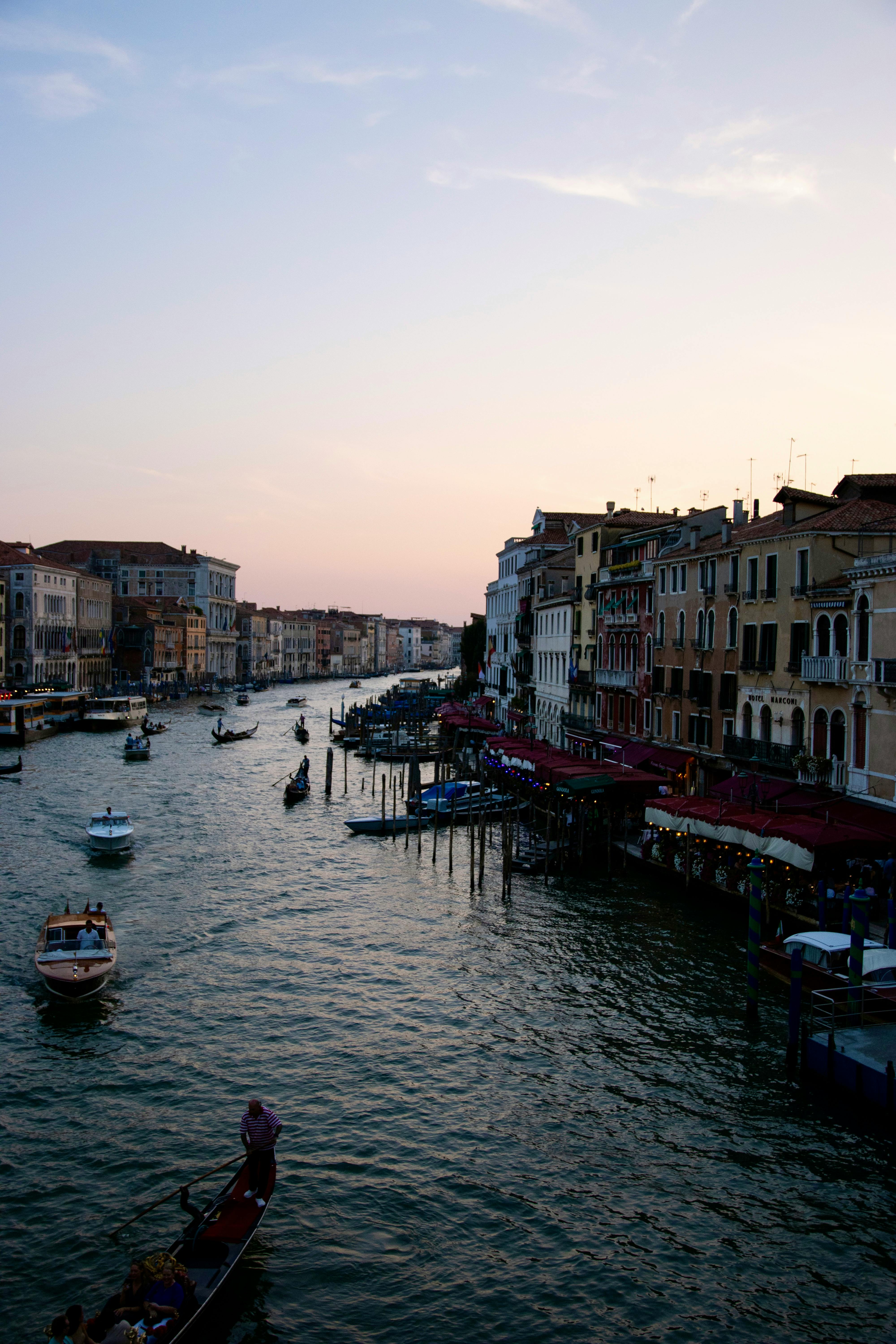 Serene sunset over Venice's Grand Canal with gondolas gliding by historic buildings.