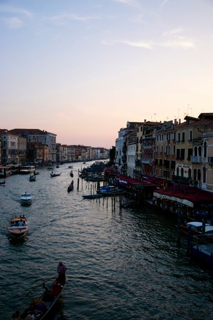Serene sunset over Venice's Grand Canal with gondolas gliding by historic buildings.