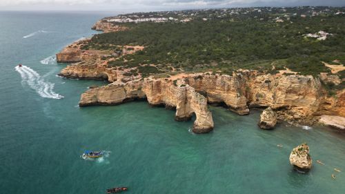 Free A breathtaking aerial view of the Algarve coastline in Portugal, showcasing stunning cliffs and turquoise waters. Stock Photo