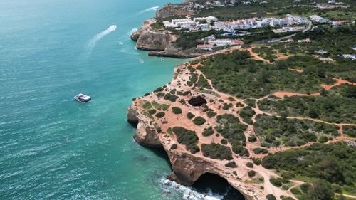 Free Stunning aerial view of the Algarve coastline with dramatic cliffs and turquoise waters in Portugal. Stock Photo