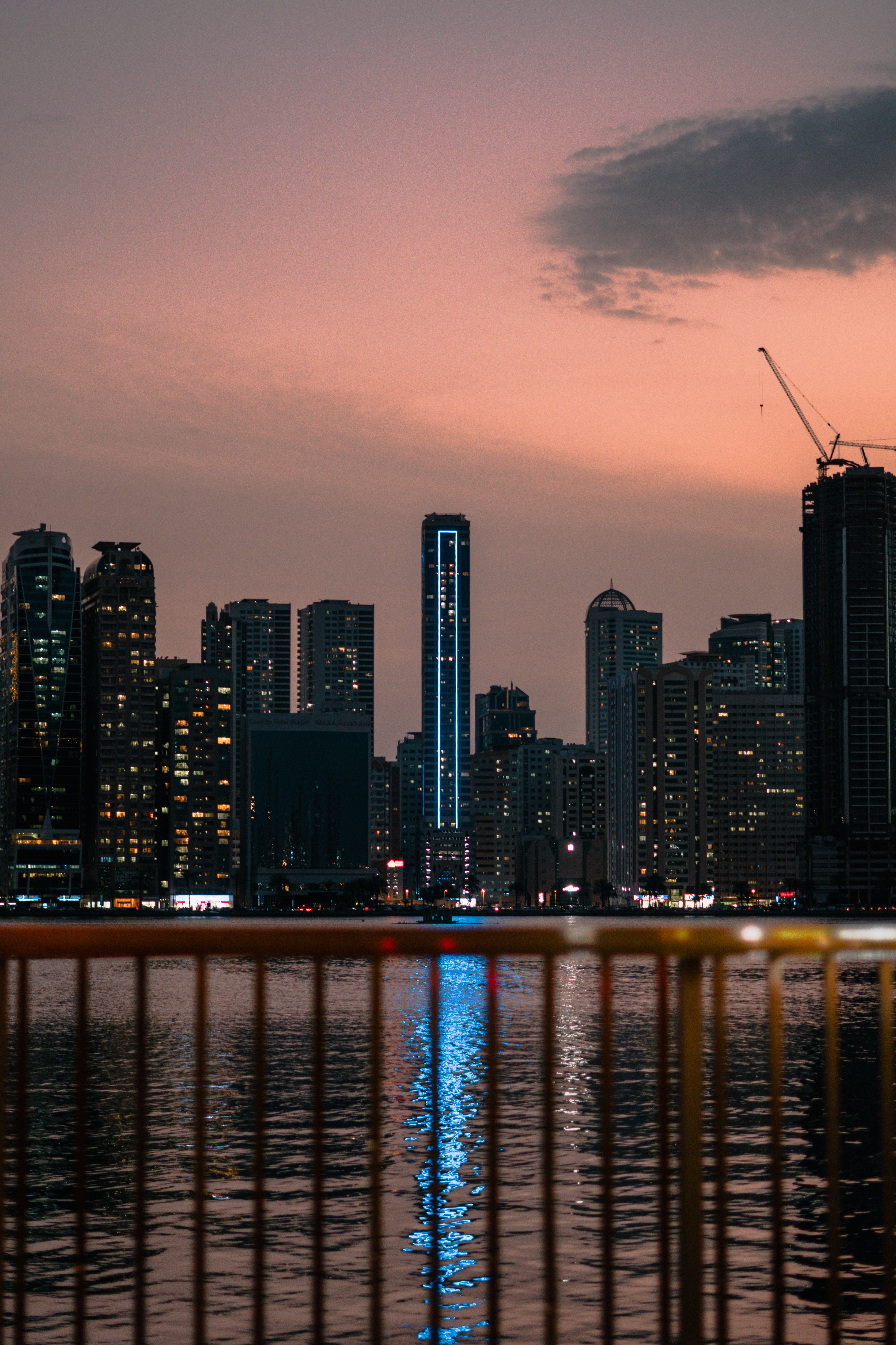 Illuminated Sharjah skyline reflecting on water at twilight, signalling a low-cost UAE business base
